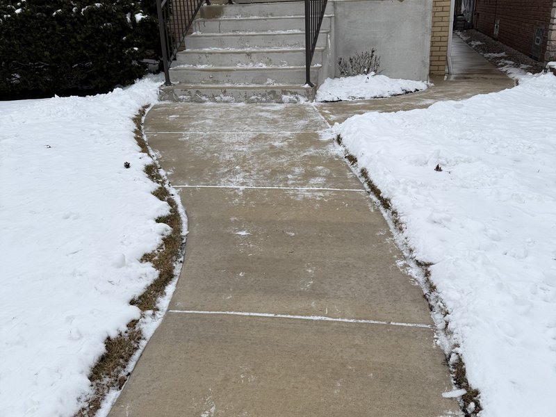 After residential snow removal by Snow Bosses — front walk and steps cleared to bare concrete