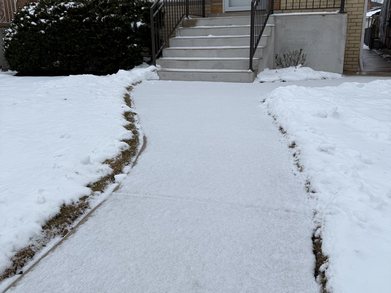 Before snow removal in Chicago — snow-covered front walk and steps at a home