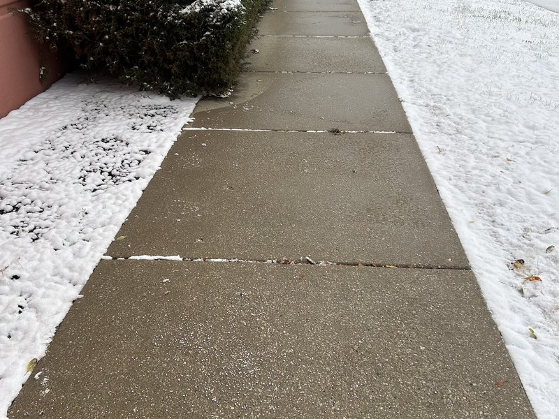On-demand snow removal in Chicago — commercial sidewalk cleared to bare concrete, snow edged back