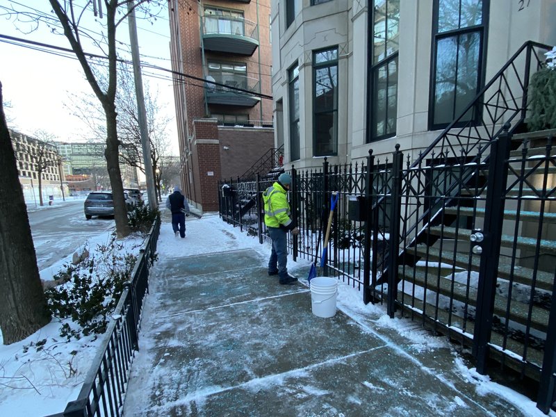 Snow Bosses crew shoveling and salting a Chicago sidewalk during on-demand snow removal